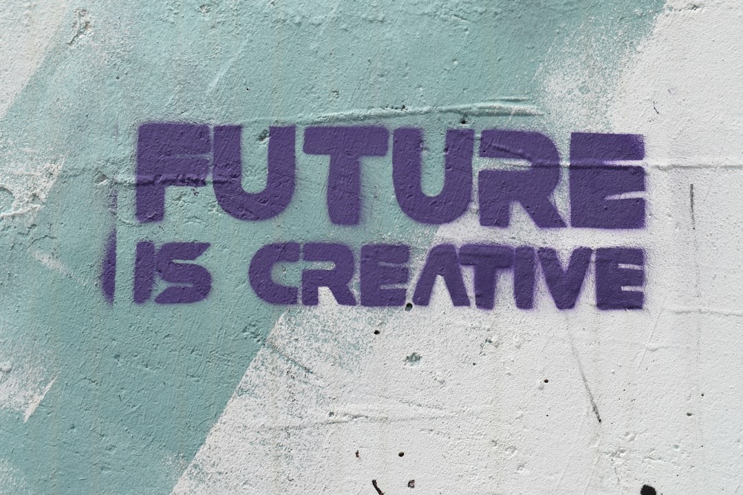 Purple graffiti on a textured wall reads 'FUTURE IS CREATIVE'.